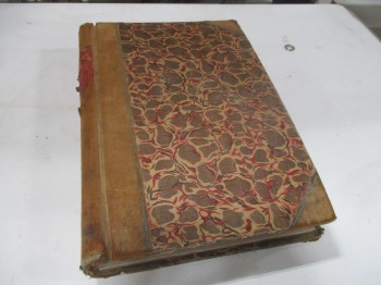 Book, Ledger, Mottled Brown Cover With Brown Leather Corners And Spine. Very Worn Illegible Red Label.
